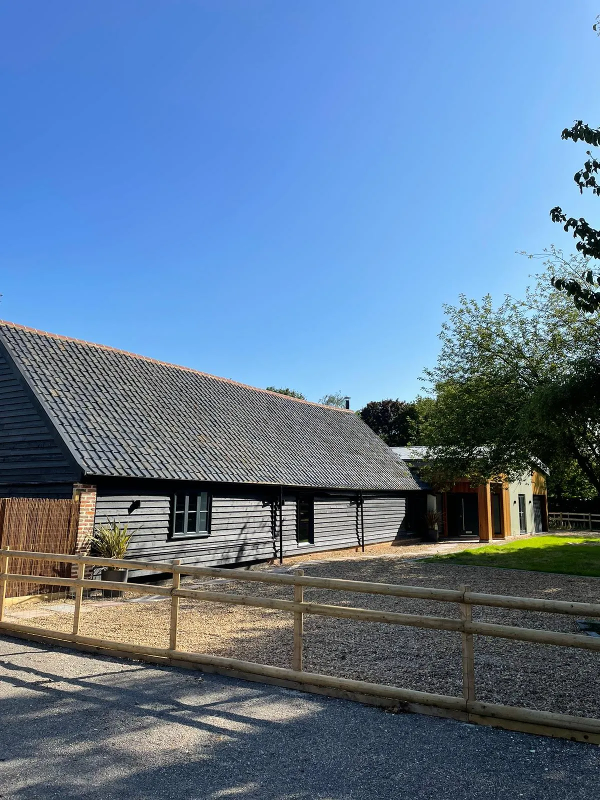 a black barn with a wooden fence around it