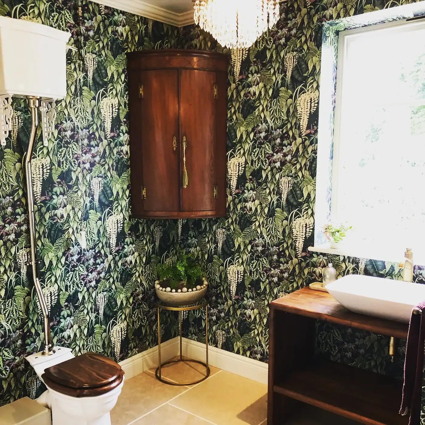 a bathroom with a toilet, sink, and mirror