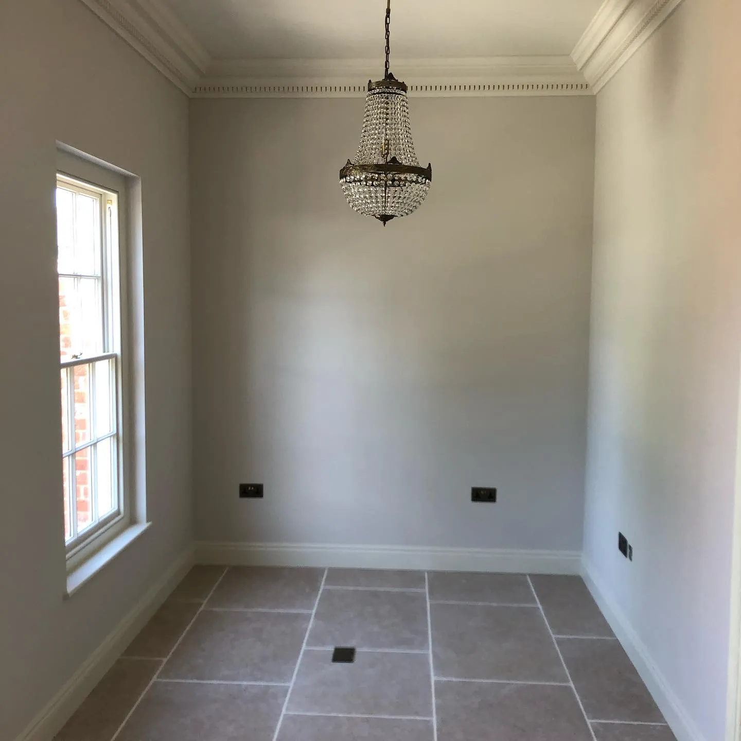 an empty room with a chandelier hanging from the ceiling