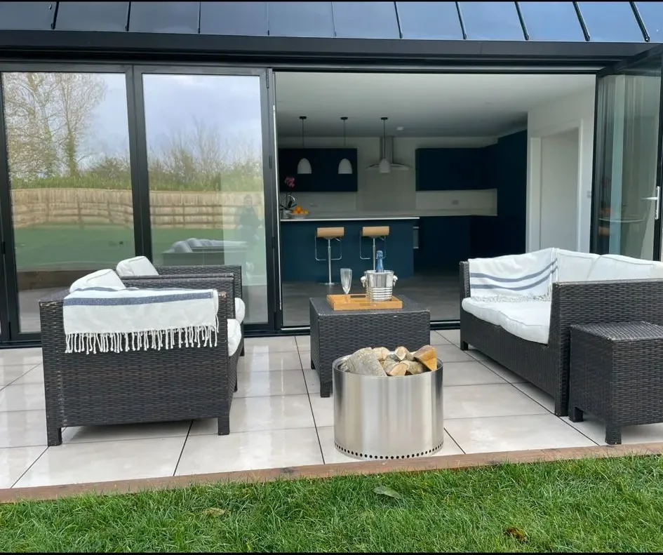 A patio with wicker furniture and a fire pit.