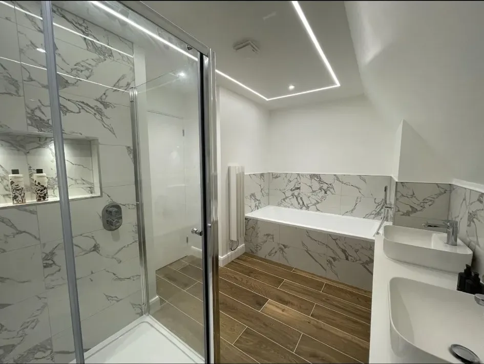 A bathroom with a shower, sink, and toilet.