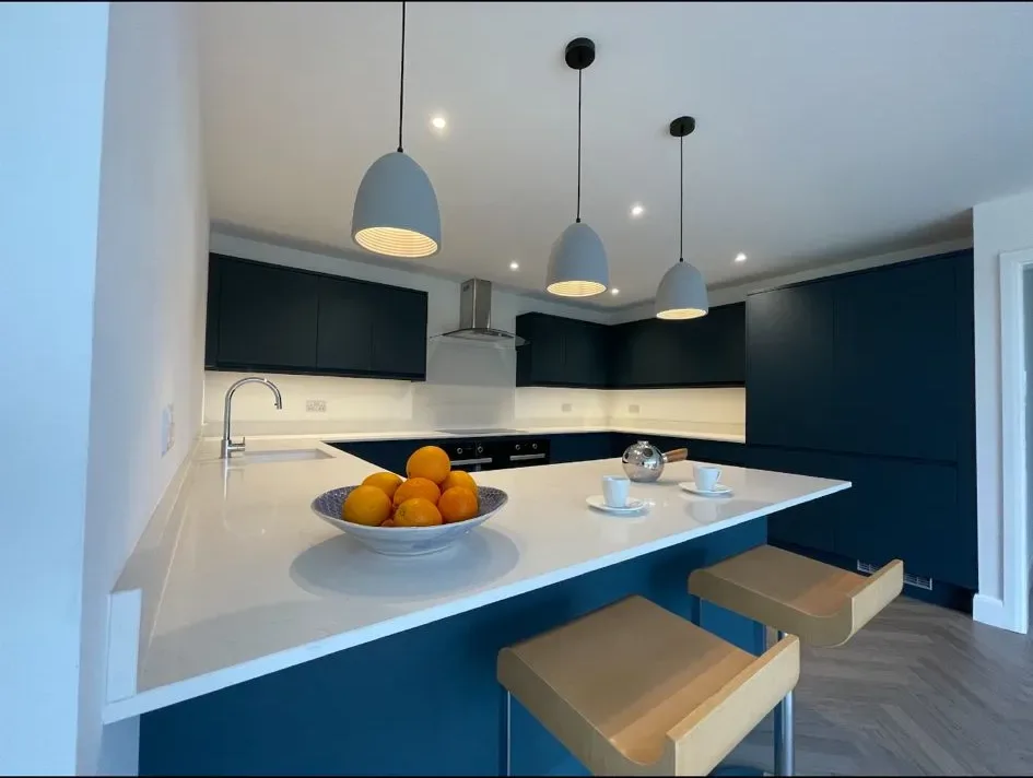 A bowl of oranges sitting on a counter in a kitchen.