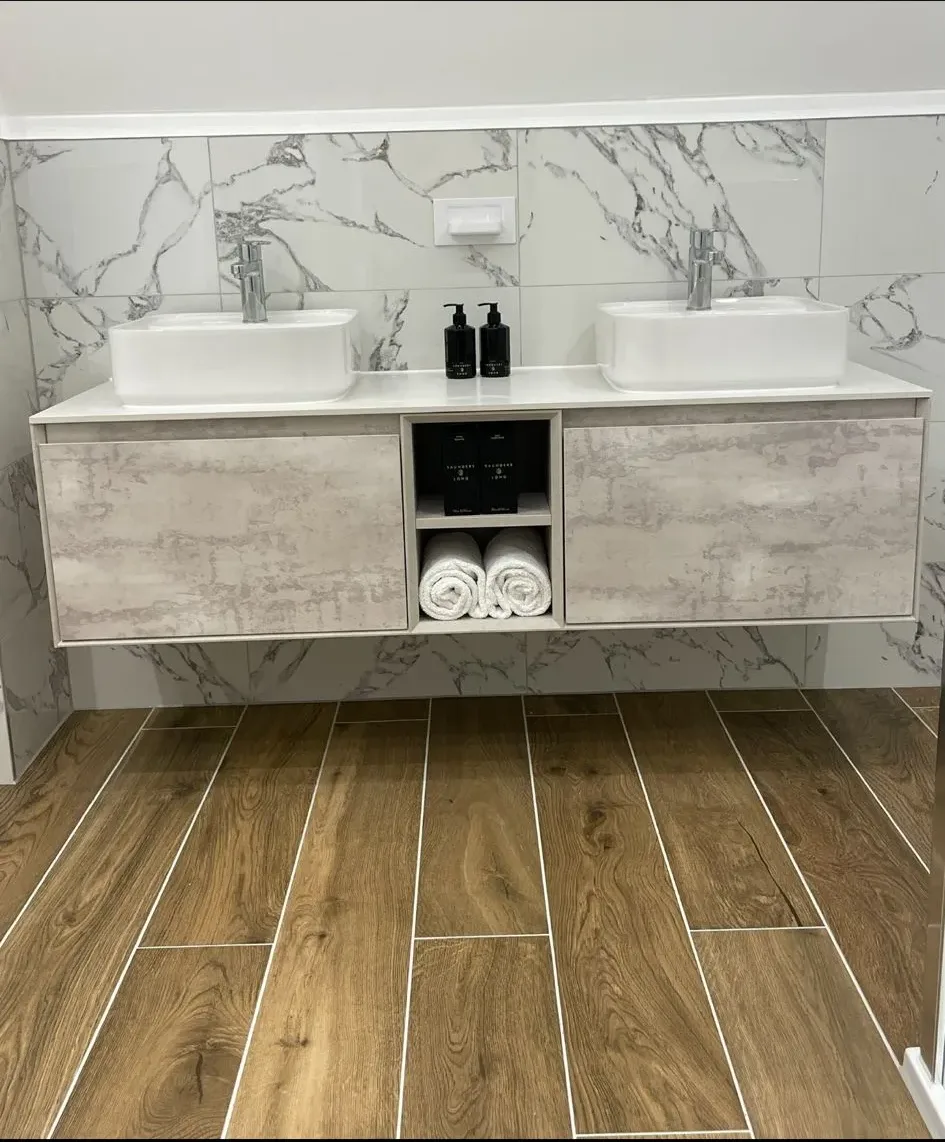 A bathroom with two sinks and a marble counter top.