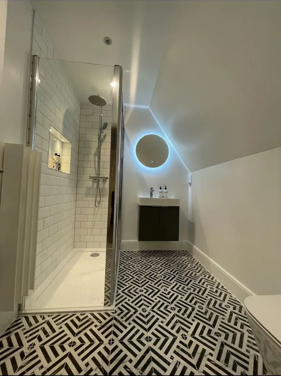 A bathroom with a black and white tile floor.