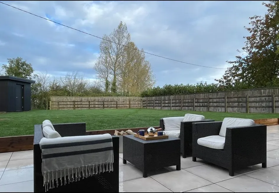 A patio with chairs, a table and a grill.