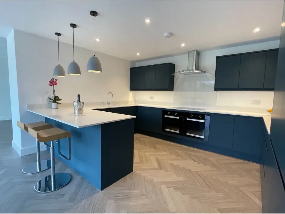 A kitchen with a center island and two stools.