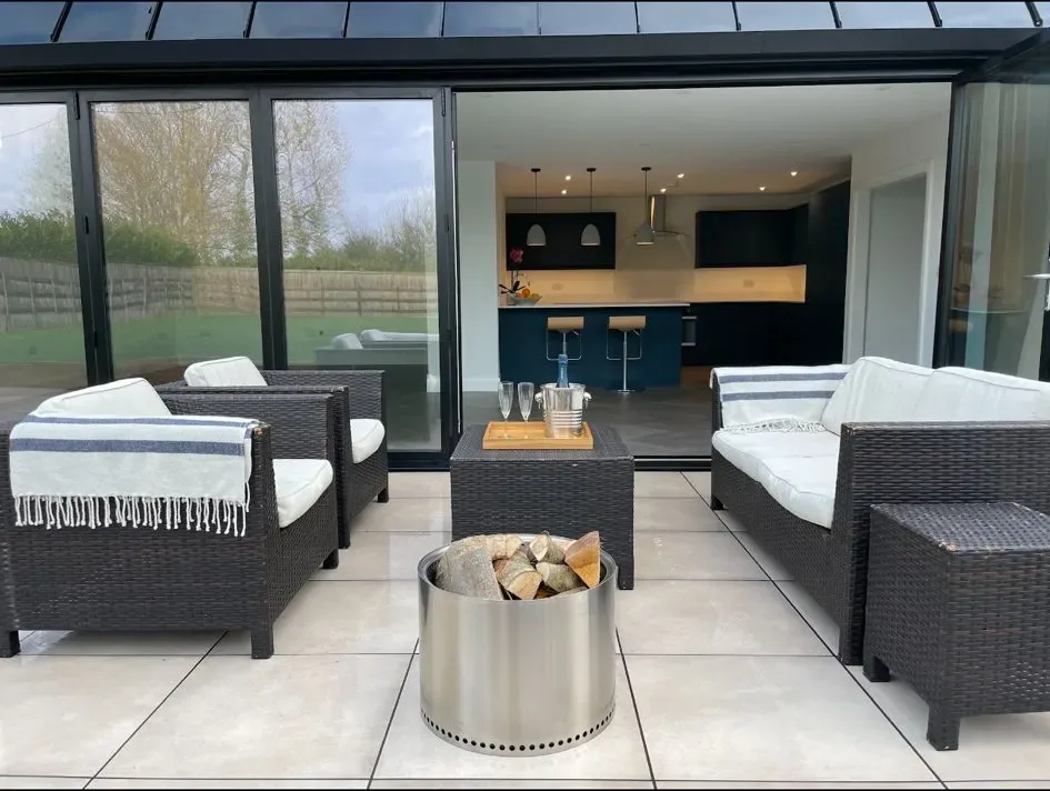 A patio area with wicker furniture and a fire pit.